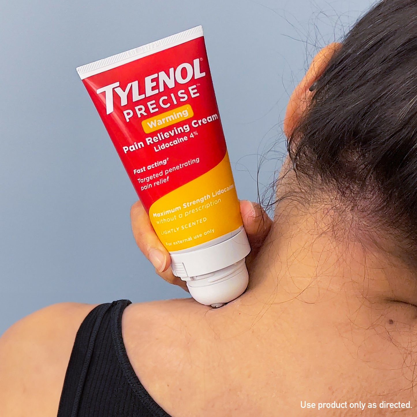 A woman applying Tylenol Precise Warming Pain Relieving Cream to her neck