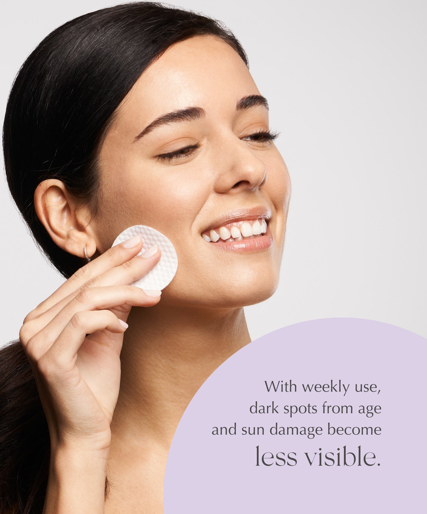 A woman swiping an Exuviance Pure Retinol Correcting Peel Pad over her cheek