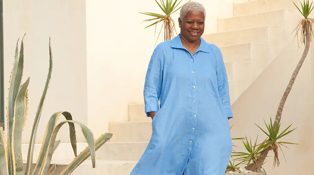 a woman dressed in a flowy blue dress, perfect for a person experiencing menopause hot flashes