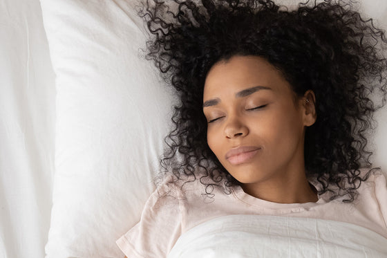 a woman sleeping, thinking about how to choose the best bedding for night sweats