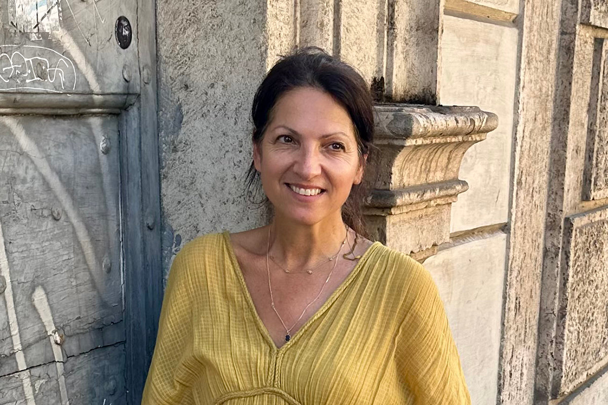 Person standing against a stone wall, representing a reflective moment in the menopause hormone therapy journey.